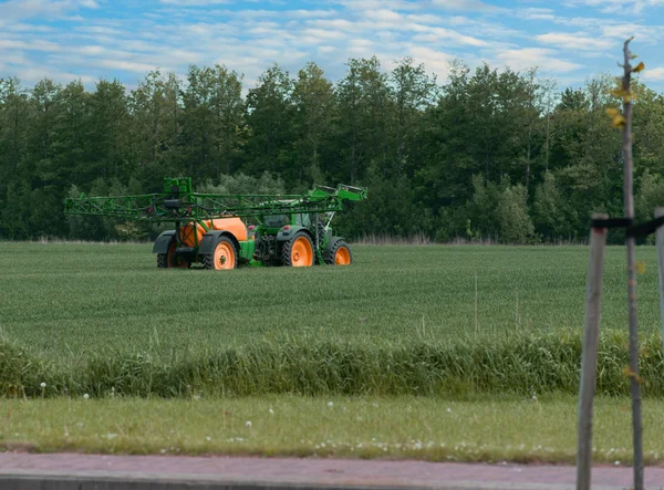 Трактор с опрыскивателем при применении пестицидов — стоковое фото