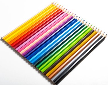 Beyaz arkaplana dizilmiş farklı renklerdeki renkli kalemler