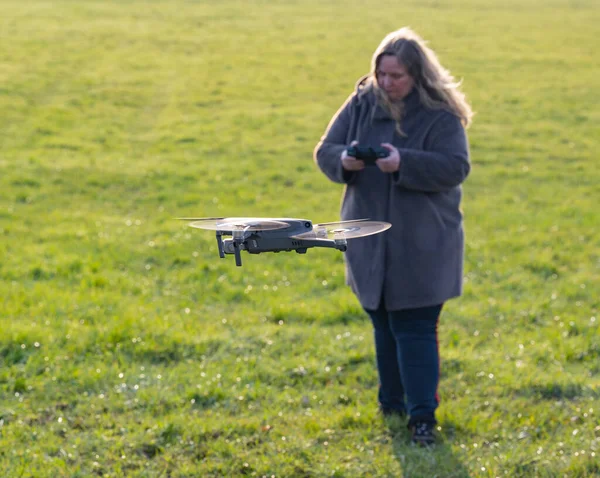 Dji Mavic ProドローンDjiのドローンは 女性パイロットによって緑の草原を飛行します — ストック写真