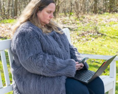 Tavşan kürklü bir kadın bahçede çalışıyor. Evinde bir defter var.