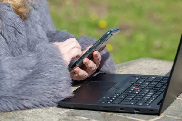 ウサギの毛皮のジャケットの女性は 自宅のオフィスでノートと庭で動作します — ストック写真