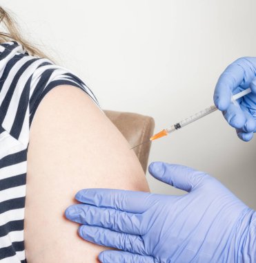 Kadın, BioNTech 'ten COVID-19 mRNA COMIRNATY aşısı ile aşılandı.