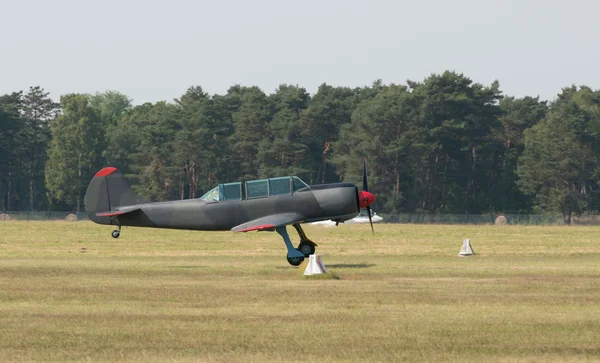 Airplane landing in field — Stock Photo, Image