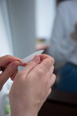 Tırnak bakımı. Kız tırnak törpüsüyle tırnaklarını biliyor. Kırık bir tırnak. Manikür manikürle ilgilenen kız tırnak törpüsü kırık tırnak