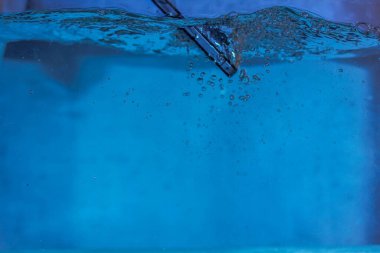 Siyah beyaz telefon suya düştü. Suda telefon. Su kabarcıklarında telefon. Telefon suya batıyor.