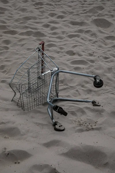 超市商店的购物车躺在沙漠的白沙中间 文明对自然的污染 破坏自然 人类在乱扔垃圾人类在污染 — 图库照片
