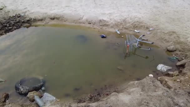 Carrello Del Supermercato Disteso Una Pozzanghera Dopo Pioggia Circondato Mucchio — Video Stock