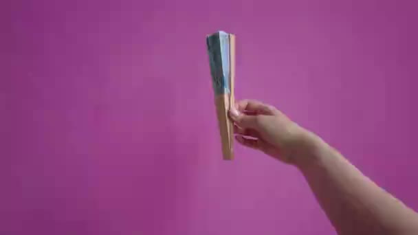Een Hand Opent Een Ventilator Een Roze Achtergrond — Stockvideo