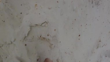 Bir adam çölde yürüyor. Kumların üzerinde bitkin bir şekilde yürüyen bir adamın ayakları. Bir mülteci. Kumlarda kaybolmuş bir göçmen.
