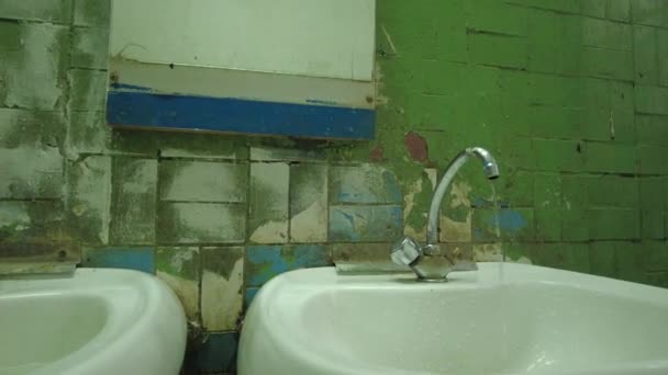 水从水龙头滴入水槽 滴入有碎瓦的房间 形成一个可怕的旧卫生间和一个水槽 — 图库视频影像