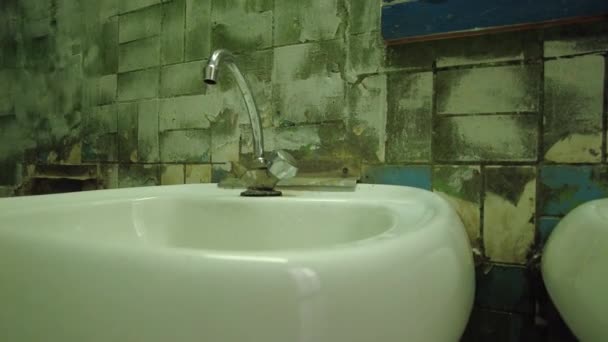 水道水が崩壊したタイルで部屋に流し込み 古い恐ろしいトイレの部屋とシンクを成形します — ストック動画