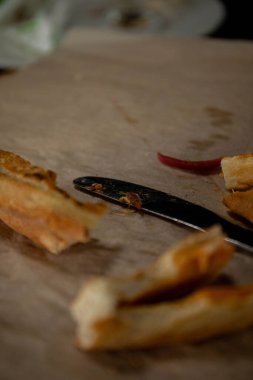 Isırılmış pizza dilimleri bir bıçak ve çatallı pizza kabuğunun yanında bir tepside duruyordu.