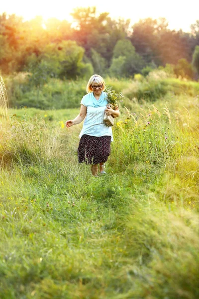 Donna Sullo Sfondo Del Tramonto Prato Piedi Con Portafoglio Fiori — Foto Stock