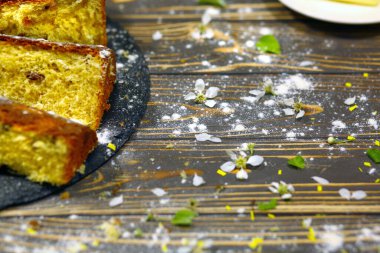 Easter cake and slices top view, on the dark wood background. Homemade baking. Easter concept. Copy space on the right.