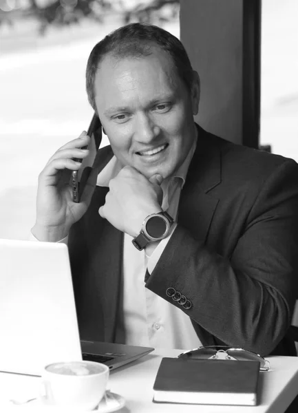 Черно Белый Портрет Улыбающегося Молодого Бизнесмена Разговаривающего Смартфону Сидящего Столом — стоковое фото