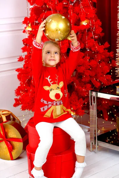 Aranyos Kaukázusi Lány Piros Karácsonyi Pulóverben Játszik Egy Arany Labdával — Stock Fotó