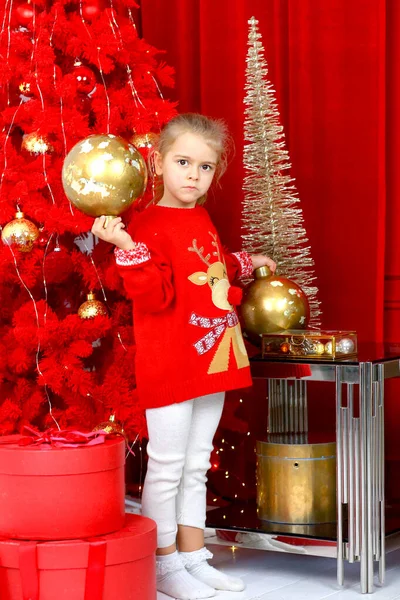 Uma Menina Caucasiana Bonito Suéter Natal Vermelho Segurando Uma Bola — Fotografia de Stock