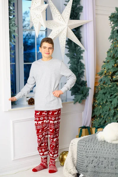 Mladý Chlapec Stojí Okna Pyžamu Vánoce Pozadí Krásný Útulný Interiér — Stock fotografie