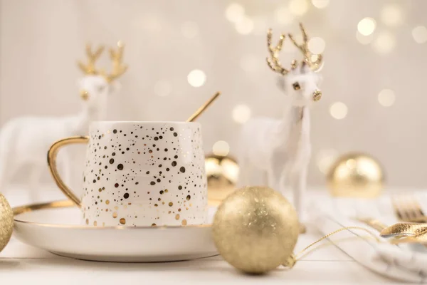 Beautiful composition with white Cup with the gold new year\'s drink.