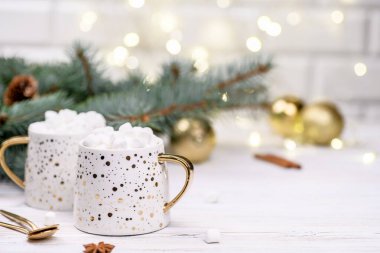 Beyaz kapuçino ya da altın bokeh 'in üzerinde noel ağacı olan kakao, yeni yıl içeceği..