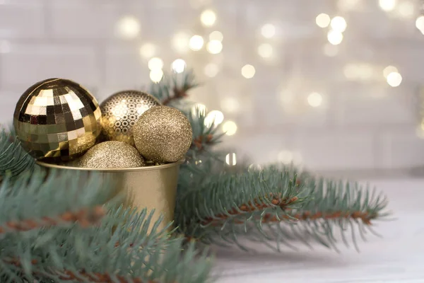 木制背景和圣诞树枝条上的精美的圣诞金制玩具桶 — 图库照片