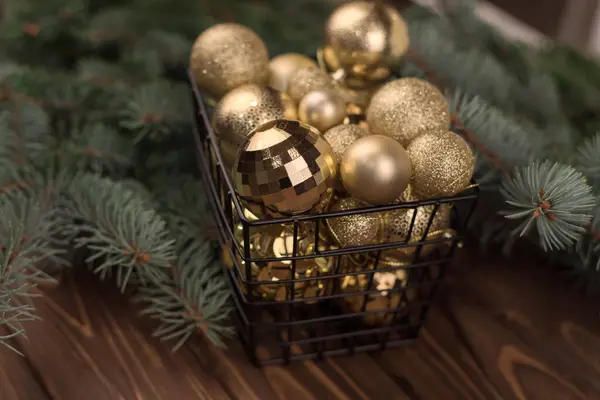 一盒精美的圣诞金制玩具放在木制背景和圣诞树枝条上 复制及垃圾邮件 — 图库照片