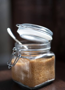 Siyah zemin üzerinde kahverengi şeker kamışı olan şeffaf cam kavanoz.