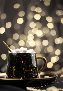 Siyah bir Noel arkaplanında altın kakaolu lokum kaplı ev yapımı sıcak çikolata..