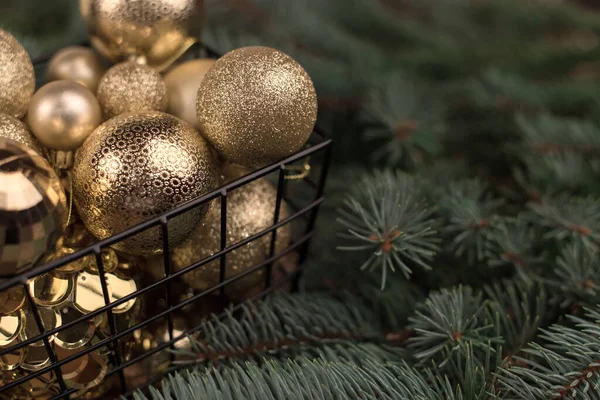 圣诞树下的树枝上挂着一桶别致的圣诞金黄色玩具 — 图库照片