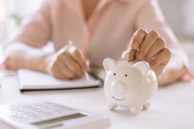 Yaşlı kadınların elleri domuz kumbarasına para yatırdı. Emeklilik ve tasarruf kavramı..