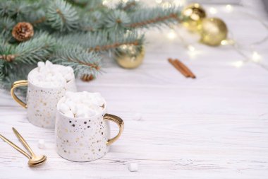 Beyaz kapuçino ya da altın bokeh 'in üzerinde noel ağacı olan kakao, yeni yıl içeceği..