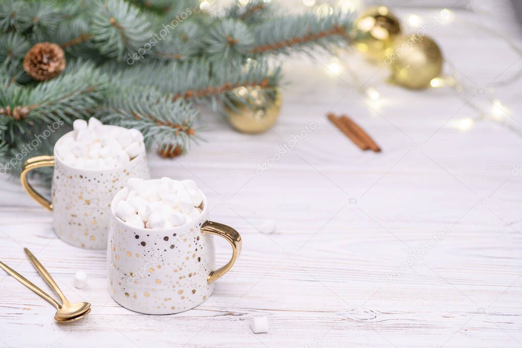 White cup of cappuccino or cocoa with christmas tree on the buckground of gold bokeh, New Year hot drink.
