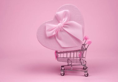 Sevgililer Günü için pembe, kalp şeklinde hediye. Pembe bir arka planda, minimalizm..