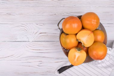 Ahşap zemin üzerinde lezzetli olgun hurma meyvesi.