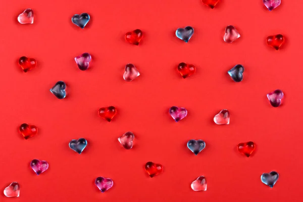 Eine Streuung Farbiger Glasherzen Auf Rotem Hintergrund Zum Valentinstag — Stockfoto