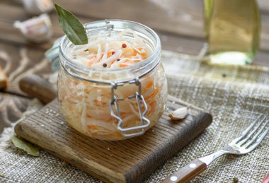 Ekşi, salamura lahana turşusu, havuç ve defne yaprakları cam kavanozda..