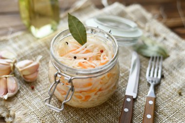 Ekşi, salamura lahana turşusu, havuç ve defne yaprakları cam kavanozda..