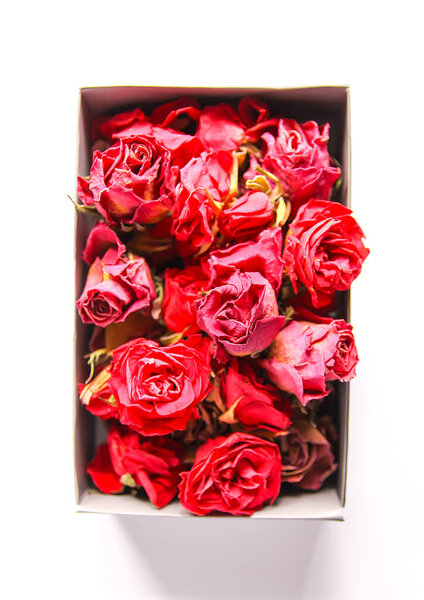 Red rose dried buds, flowers and petals in the opened cardboard box