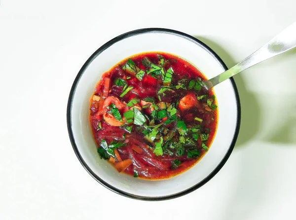 Beyaz arka planda beyaz bir tabakta Rus ve Ukrayna geleneksel kırmızı çorba çorbası.