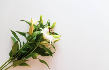 Ilık mum ışığında beyaz zambak çiçekleri..