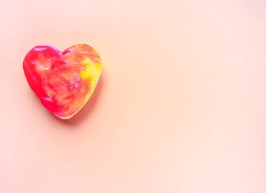 Yumuşak arkaplanda kalp şeklinde renkli sabun.
