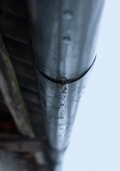 溶化的冰柱挂在排水管道上关闭 — 图库照片