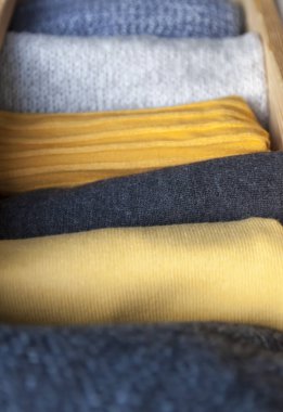 Ilık yün elbiseli ahşap şifonyer çekmecesini aç. Ev dikey depolama. Gardırop organizasyonu. Moda renkleri.