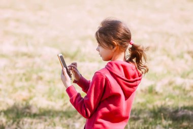 Baharda açık havada cep telefonu olan bir kız.