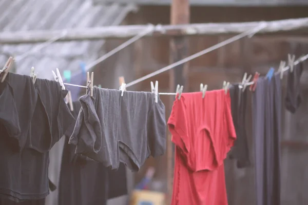 Colorful clothes and laundry hanging on a clothesline in country yard.