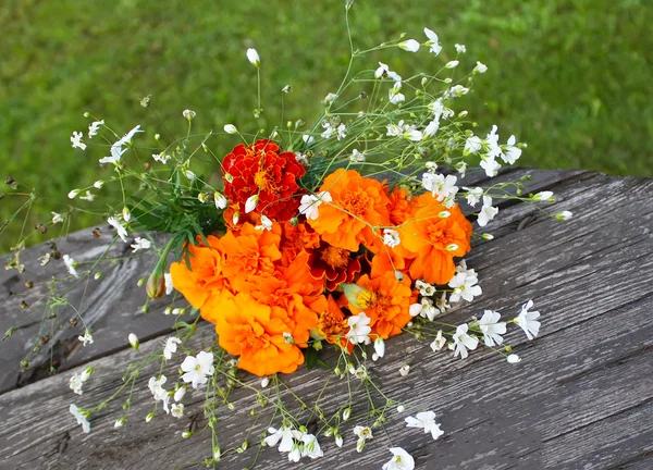 Bouquet on flowers on wooden table — Stock Photo, Image