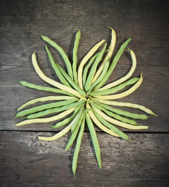 Green beans on old wooden board — Stock Photo, Image