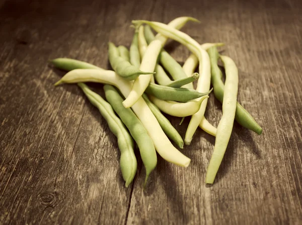 Green beans on old wooden board — Stock Photo, Image