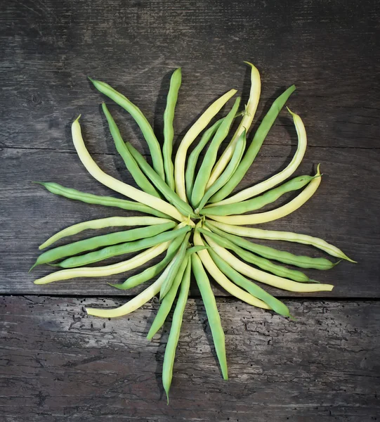 Green beans on old wooden board — Stock Photo, Image