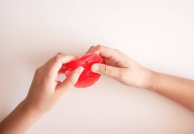 Renkli balçık sıkan küçük eller. Duyusal eğlence ve erken öğrenmeyi öneriyor..